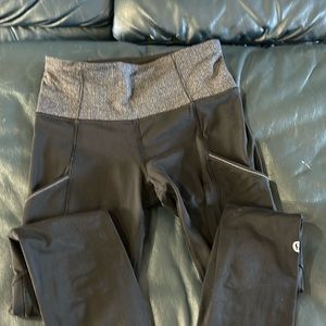 Black lululemon compression leggings with front pockets and zipper back pocket.